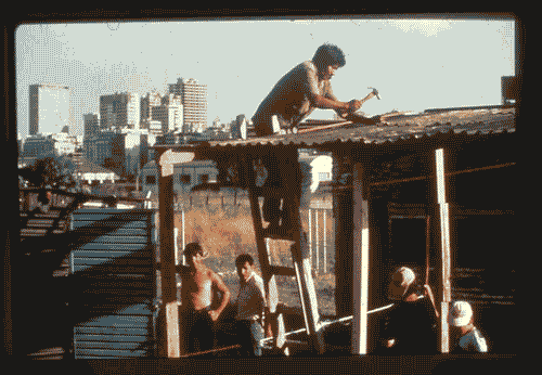 Image for XVII Triennale - Le città del mondo e il futuro delle metropoli - Partecipazioni internazionali - Sezione UNDP Programma delle Nazioni Unite per lo sviluppo - Uomini costruiscono una baracca in una Shantytown